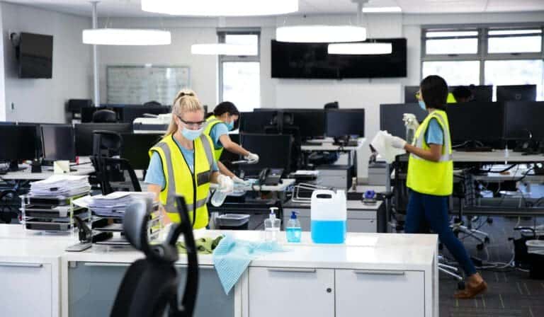 Home 2 Team wearing hi vis vest and face mask cleaning the office using disinfectant